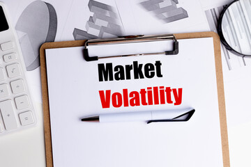 Market volatility concept with clipboard, pen, calculator and financial charts on white office desk