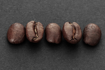 Closeup Of Five Roasted Coffee Beans On Dark Slate Background For Stock Photo