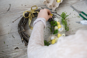 DIY process of woman making candid Easter wreath arrangement decor. Small business, self employed entrepreneur, self-made career. Series of handmade craft instruction. Zero waste eco-friendly