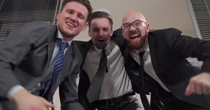 Businessmen in office celebrate success with fun dance. Happy men enjoy a lively office party celebration, colleagues bond and team morale rises. Strong teamwork and business success concept.