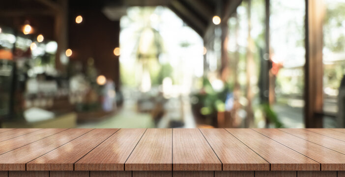 Empty wooden table top with lights bokeh on blur restaurant background.
