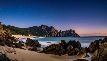 Tropical beach at dusk with rocky shore and soft purple sunset sky over ocean waves
