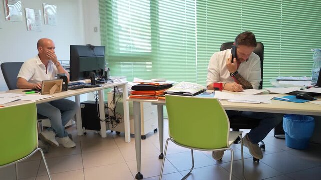 Office staff working diligently in an electrician company&rsquo;s modern office environment