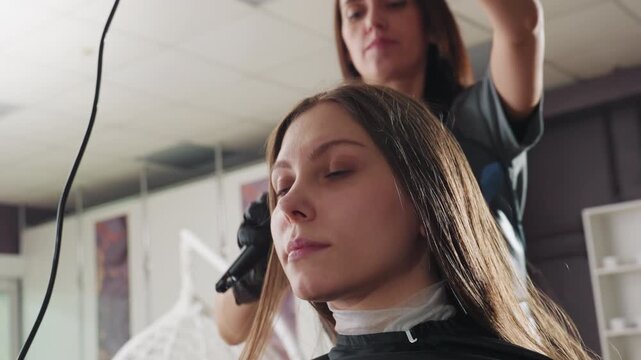 hair styling process, professional stylist enhances hair volume through precise technique, expert stylist achieves lift and fullness utilizing specialized tools and careful attention every step