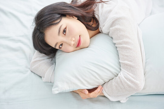 Young woman sleeping peacefully on pillow in bed.