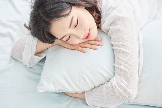 Young woman sleeping peacefully on pillow in bed.