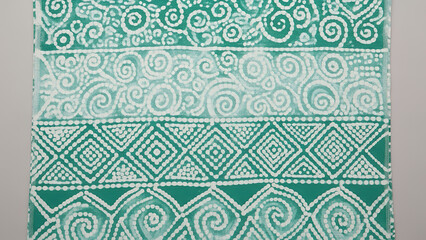 Adire fabric with vibrant patterns and green tones showcasing traditional textile art