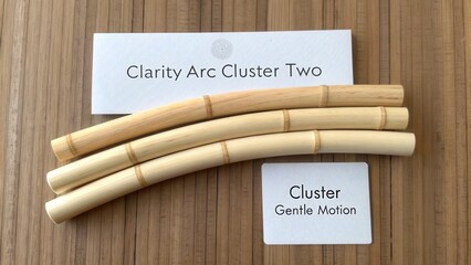 Three Elegant Wooden Bamboo Sticks Resting on Natural Wood Background with Informative Cards for Crafts and Design