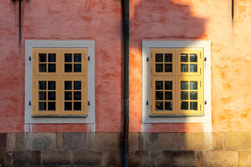 Building exterior with pink wall and yellow window frame.