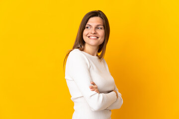 Fototapeta premium Young Slovak woman isolated on yellow background with arms crossed and happy