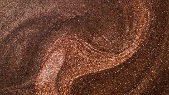 Mesmerizing video of fluid golden paint coiling into an elegant, sustained wave pattern, showcasing dynamic flow and luxurious shimmering effect of particles.