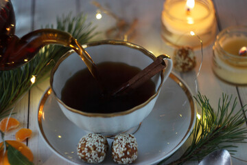 Tea from a transparent teapot is poured into a mug