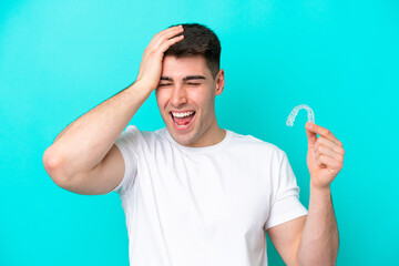 Fototapeta premium Young caucasian man wearing holding invisible braces isolated on blue background has realized something and intending the solution