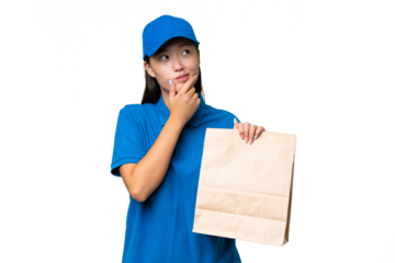 Young Asian woman taking a bag of takeaway food over isolated background having doubts