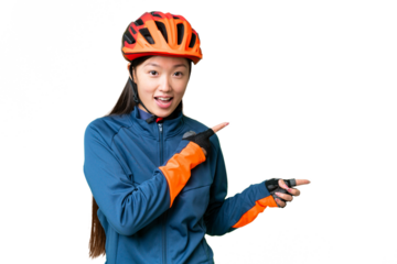 Young cyclist woman over isolated chroma key background surprised and pointing side