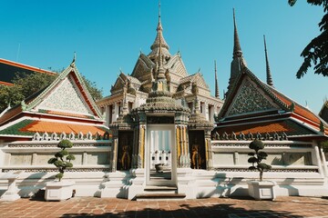 Fototapeta premium Ornate Entrance and Porcelain Decorated Pagodas at Wat Phra Temple, Bangkok