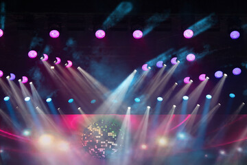 Vibrant light display with colorful beams and a disco ball during a lively night event in an indoor...