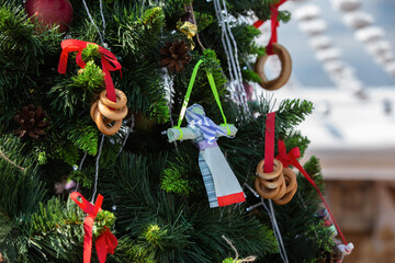 Colorful decorations on a festive holiday tree at an outdoor event in December with traditional ornaments and crafts