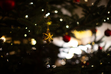 Decorated Christmas tree with golden star ornament and glowing lights in a cozy indoor setting