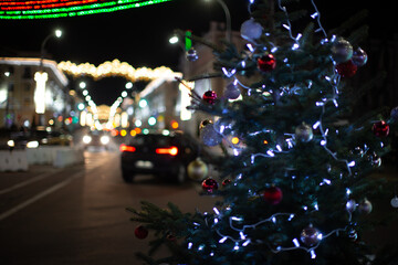 City street adorned with holiday lights and decorations during a festive evening celebration