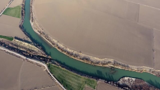 Aerial view of brown fields and irrigation canals surrounding the Nile River alluvial plain. Fertile floodplain patterns reveal agricultural geometry shaped by ancient river sediment.