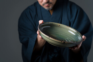 皿を持つ陶芸家の男性