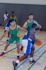 African american male player in jersey dribbling basketball at gym right side, copy space