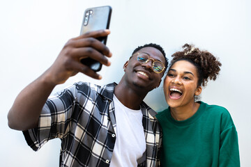 Smiling diverse couple taking selfie using smartphone together