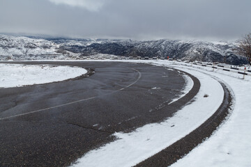 Snowy winter mountain road in Armenia with scenic landscape, icy conditions, and travel route through remote nature. Cold season transportation concept with wilderness, snowfall and driving conditions