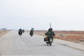 Armed Soldiers Riding Motorcycles on Desert Road, War in Syria