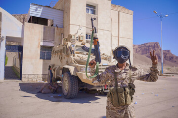 A Yemeni Armed Soldier Making Victory Sign in Military Environment