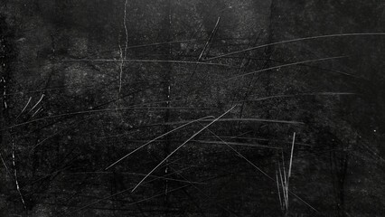 Grunge black background with scratch marks, dust, and noise. Dark abstract dirty texture with distressed overlay. White dust particles and scratches on black grunge surface.
