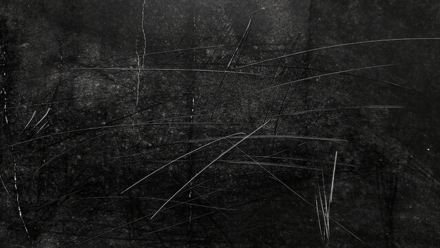 Grunge black background with scratch marks, dust, and noise. Dark abstract dirty texture with distressed overlay. White dust particles and scratches on black grunge surface.