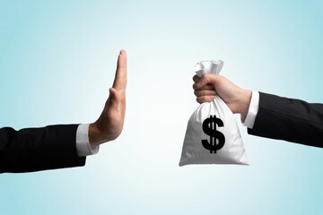 Businessman refusing money with hand gesture and white money bag