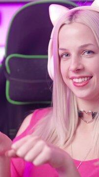 Cute blonde gamer girl with cat ear headphones in cyberspace make nyan pose