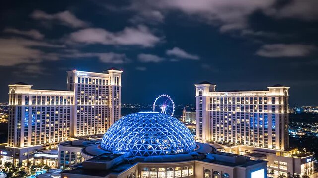 Grand building with illuminated dome and ferris wheel at night