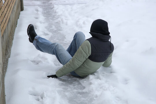 Winter Slip and Risk of Fall Accidents in Winter - a woman slips on an ice-covered road is a common winter hazard, leading to potential injuries