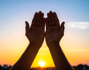 Uplifted hands silhouetted against a vibrant sunset sky, symbolizing hope