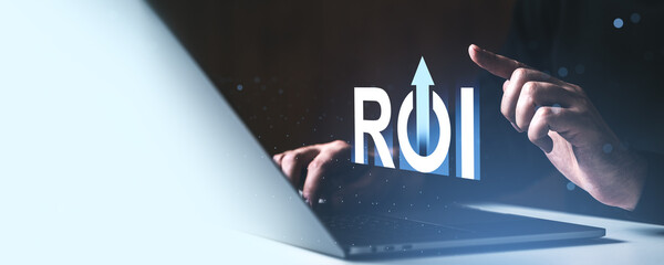 ROI growth concept with hands using laptop and glowing upward arrow symbol on futuristic background for investment and business return success theme.