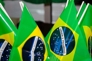 Several small Brazilian flags on plastic sticks placed in a circle. Patriotism concept