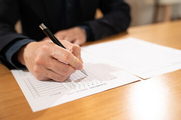 Close-up of hand filling a checklist document on a desk, representing planning, organization, task management, and business documentation.