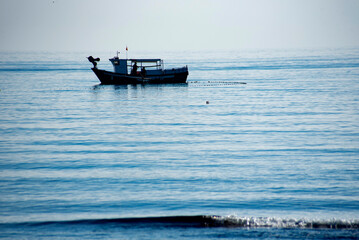 Obraz premium A small fishing boat fishing near the beach