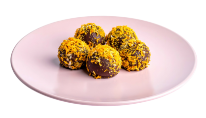 Five round chocolate treats topped with shredded orange zest served on a pink plate