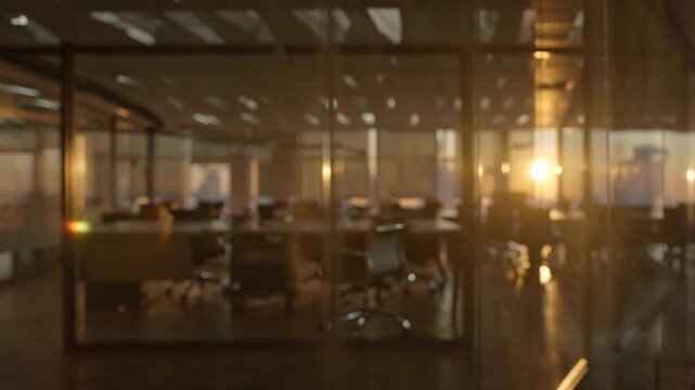 4K cinematic footage, empty modern office interior intentionally blurred, warm golden hour lighting sun rays long shadows, glass walls desks glowing amber reflections, shallow depth of field, elegant
