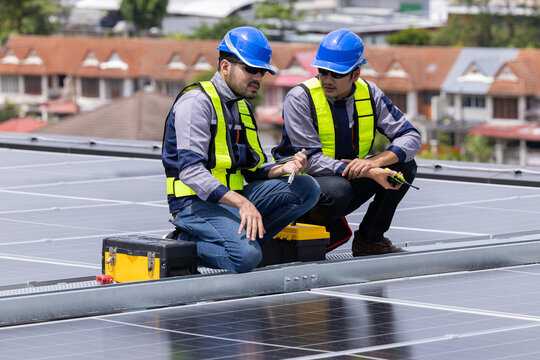 Engineers analyzing rooftop solar panel system data - Powered by Adobe