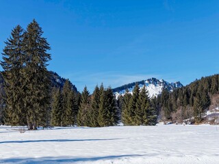 Spitzingsee in the Bavarian Alps. The frozen lake in deep winter with a view of the snow-capped Becherspitz massif

