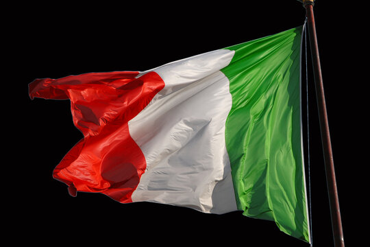 "Tricolore" the Italian flag fluttering in the wind. Green, White, Red are Italian national colors (Isolated on black background)