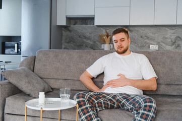 Man suffering stomach ache feeling abdominal pain at home