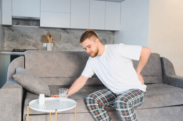 Man suffering from back pain at home