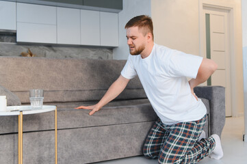 Man suffering from back pain at home